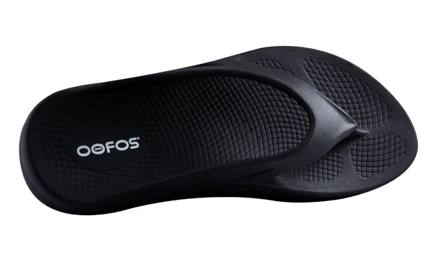 https://web.metroswimshop.com/images/oofos slide Black Thong.jpg